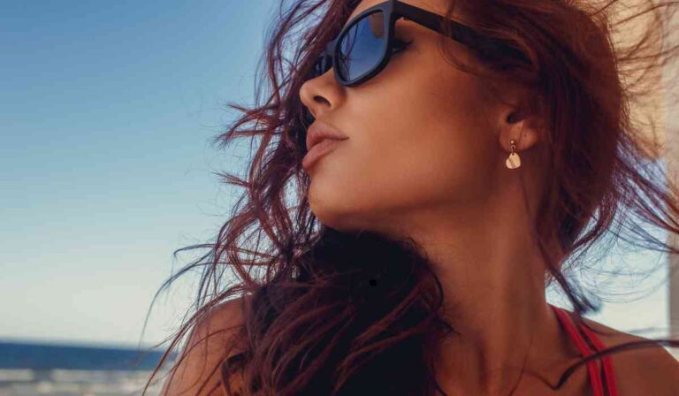 Mulher na praia com oculos de sol